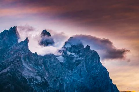 Cloudy mountain peaks at sunset Stock Photos