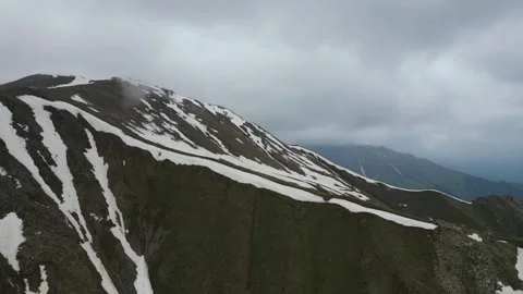 Cloudy mountain ridge with melting snow patches Stock Footage 345387003