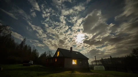Cloudy night sky with moon over lonely house in village. Stock Footage 269988063