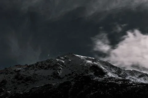 Cloudy night sky over a white summit Stock Photos