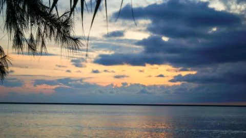 A cloudy orange evening sky at the beach Stock Photos