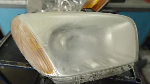 A cloudy, oxidized car headlight is ready for professional restoration Stock Footage 340153978