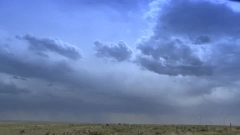Cloudy plains with windmills and single lightning strike Stock Footage 199317580