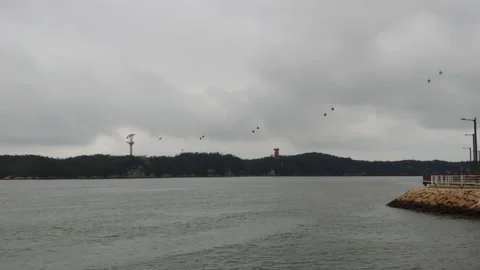 A cloudy port city scene in which cable cars move in the distance_no sound Stock Footage 137160899