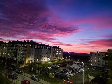 Cloudy red blue sunset over of city buildings. Evening view Stock Photos