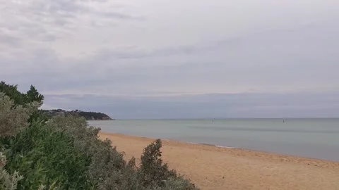 Cloudy Sandy Beach In Lowtide With Coastal Strand And Birds In The Background Stock Footage 246474932