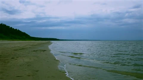 Cloudy Seashore with Gentle Waves and Sandy Beach Stock Footage 340581261