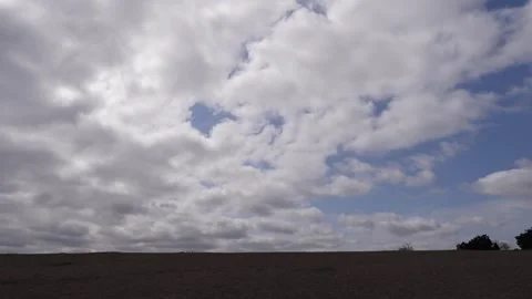 Cloudy skies and sandy beach horizon with some blue sky Stock Footage 307876900