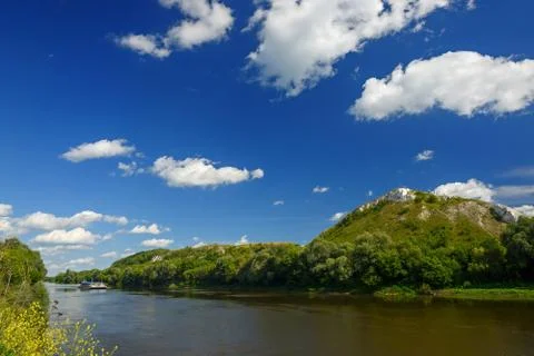 Cloudy sky above the river at the mountain. Stock Photos