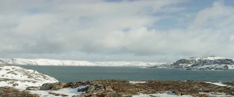 Cloudy sky and sea surrounded with snow covered mountains 库存影片 74675294