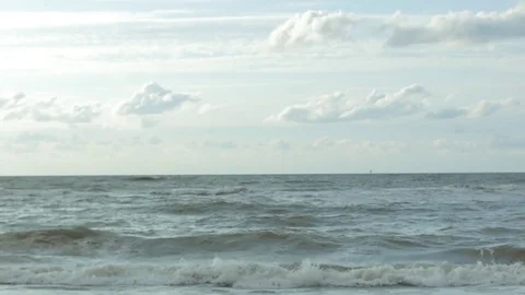 Cloudy sky and waves reaching the sea coast Stock Footage 73705430