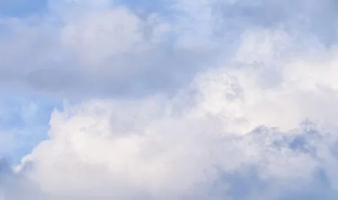 Cloudy sky background with pale pink clouds at sunset Stock Photos