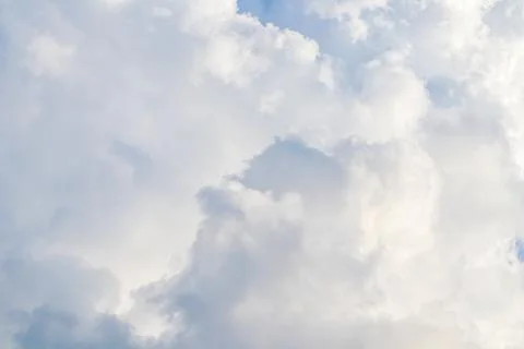 Cloudy sky background. Sunlight shining through white clouds. Stock Photos