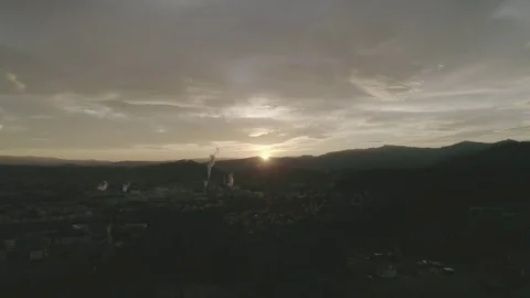 Cloudy sky with a colorful sunset over small industrial town in the valley, 4K Stock Footage 73693486