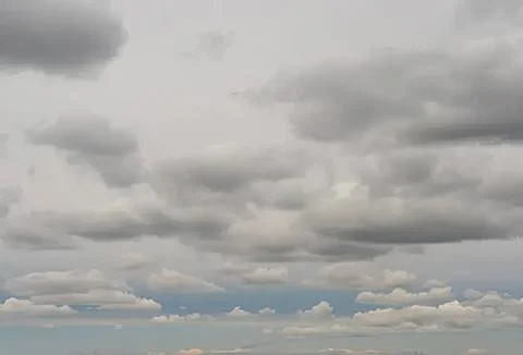 Cloudy sky with dark gray clouds over a blue horizon Stock Photos