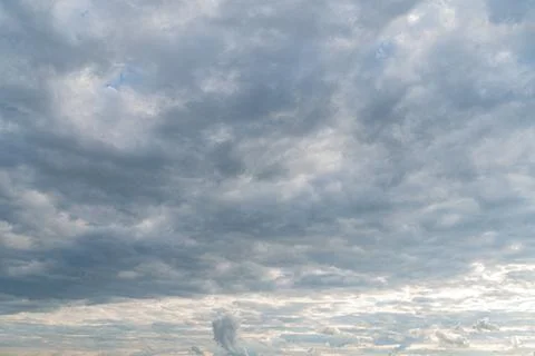 Cloudy sky with diverse, dynamic formations Gray clouds scattered, revealing  Stock Photos