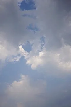 A cloudy sky with dramatic, dark grey cloud formations covering brighter white Fotos Stock