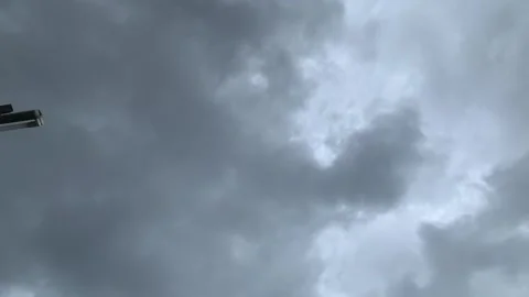 A cloudy sky filled with gray, ominous clouds. A glimpse of an object is vi.. Stock Footage 305773036