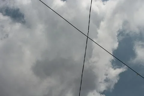 Cloudy sky with intersecting power lines Stock Photos