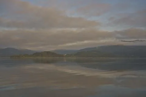 A cloudy sky with a lake in the background Stock Photos