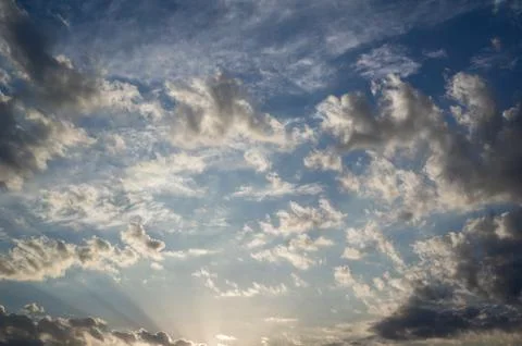 Cloudy sky is lit by evening sun. Stock Photos