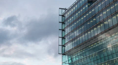 Cloudy sky with modern illuminated reflected glass  facade tilt timelapse Stock-Footage 53037252