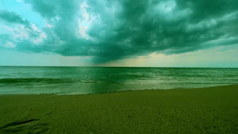 Cloudy sky over calm sea and beach, green color grading Видео 278847494