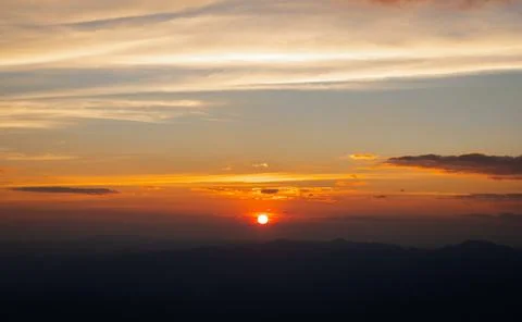 Cloudy sky over dark mountain at sunset Stock Photos