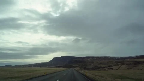 Cloudy sky over an empty Icelandic road, driver's perspective, dramatic Stock Footage 265073821