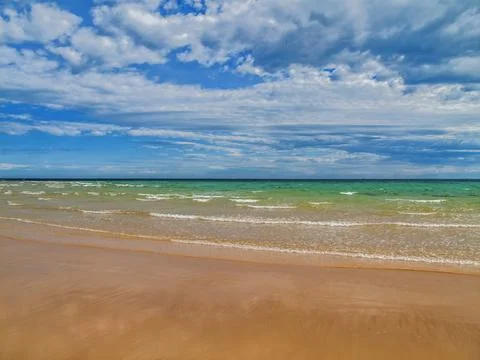 Cloudy sky over an empty sandy beach Stock Photos