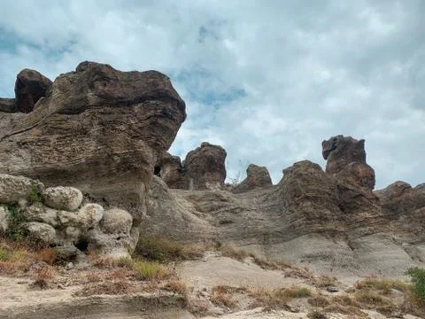 Cloudy sky over high sheer cliffs with bizarre shapes Stock Photos