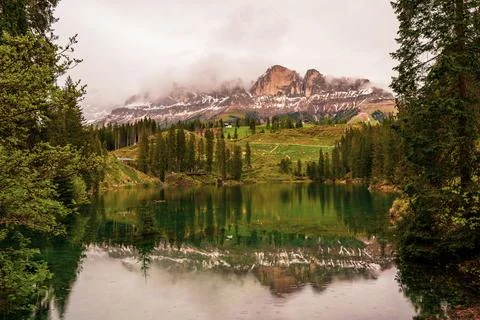 Cloudy sky over Lake Carezza in South Tyrol, Italy. Stock Photos
