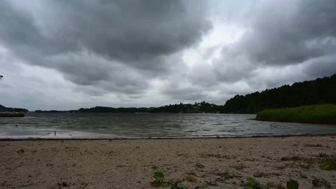 Cloudy sky over a lake with sandy shore and green trees in Norway during th.. Stock Footage 340201797