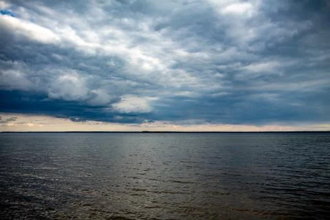 Cloudy sky over lake waves Stock Photos