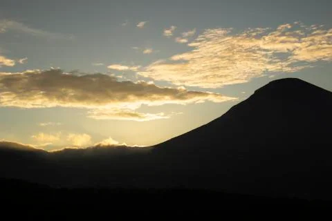 Cloudy sky over Mount Sindoro. black clouds with morning sunlight Stock Photos