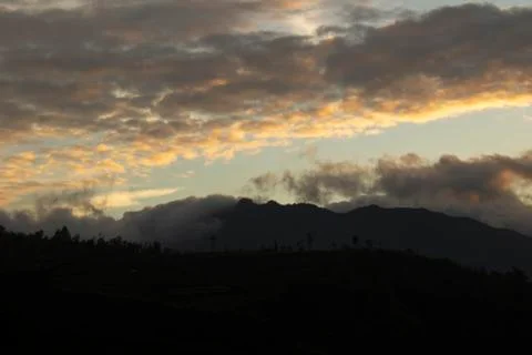 Cloudy sky over Mount Sindoro. black clouds with morning sunlight Stock Photos