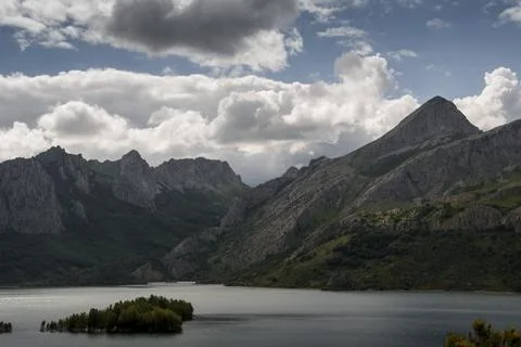 Cloudy sky over mountains range and lake Stock Photos