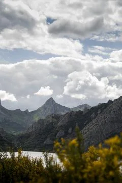 Cloudy sky over mountains range and lake Stock Photos