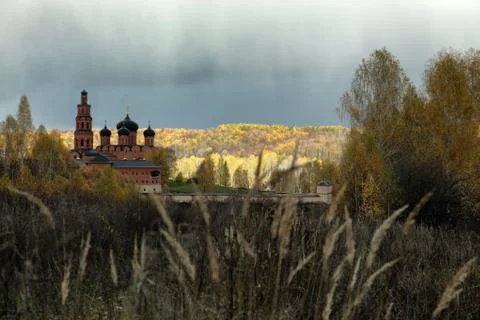 Cloudy sky over Orthodox monastery and the autumn forest Stock Photos