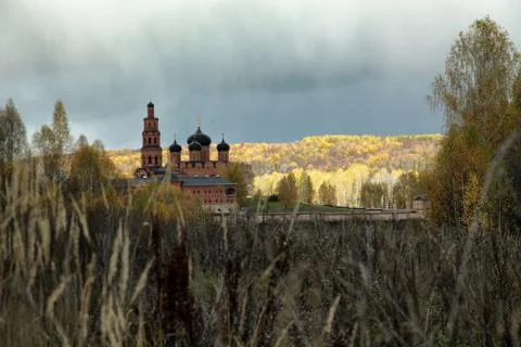 Cloudy sky over Orthodox monastery and the autumn forest Stock Photos