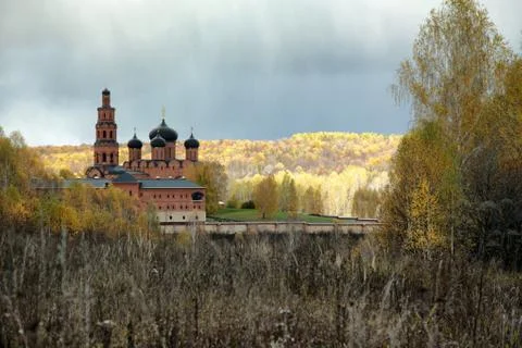 Cloudy sky over Orthodox monastery and the autumn forest Stock Photos