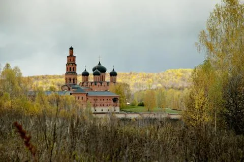 Cloudy sky over Orthodox monastery and the autumn forest Stock Photos