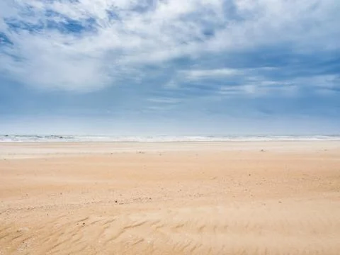 Cloudy sky over the sandy beach Stock Photos