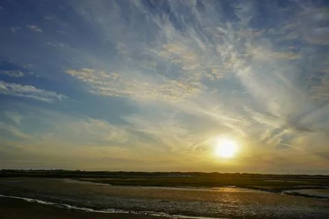 Cloudy sky over a sandy ocean shoreline 库存照片