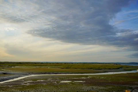 Cloudy sky over a sandy ocean shoreline 库存照片