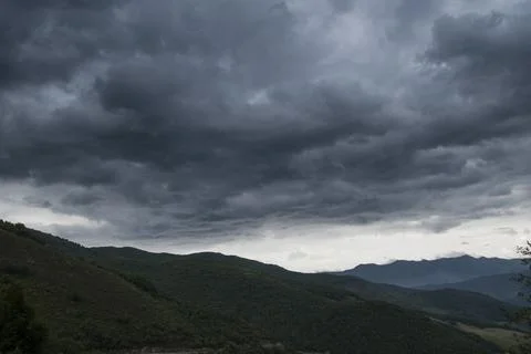 Cloudy sky with rain clouds above a mountain landscape Stock-Fotos