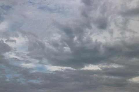 Cloudy sky with rare dark gray clouds with threat of rain Stock Photos