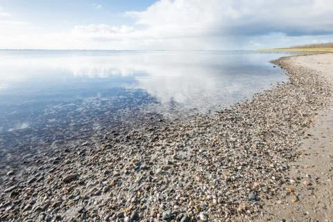 Cloudy sky reflected in the mirror-smooth surface of the water Stock Photos