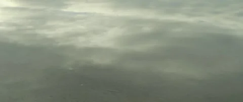 Cloudy sky reflected on shallow lake waters 5.7K scope footage Stock Footage 300541557