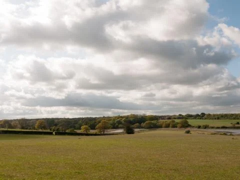 Cloudy sky in spring over a big field Stock Photos
